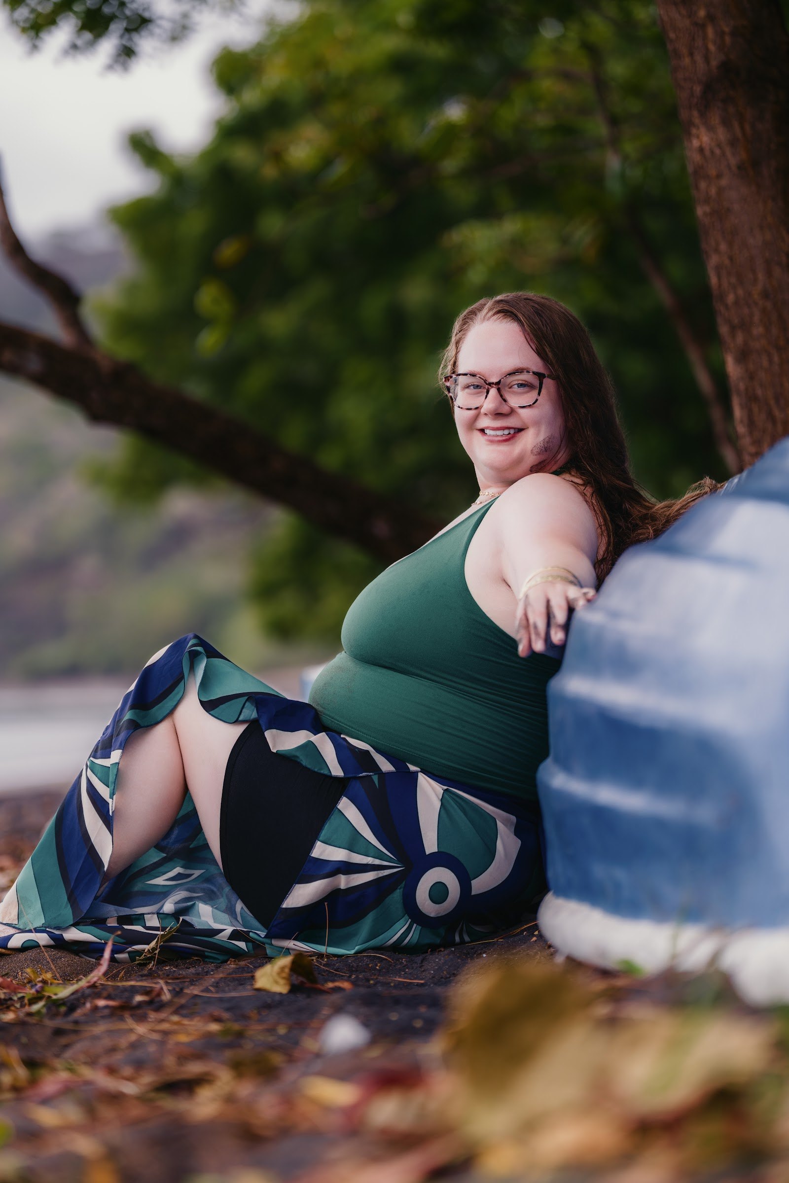 Travel advisor Mari Bay sitting beside a blue boat on the beach in Playas del Coco, Costa Rica